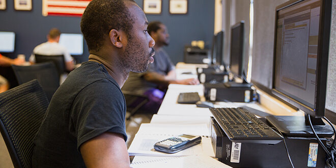 veteran student in front of computer