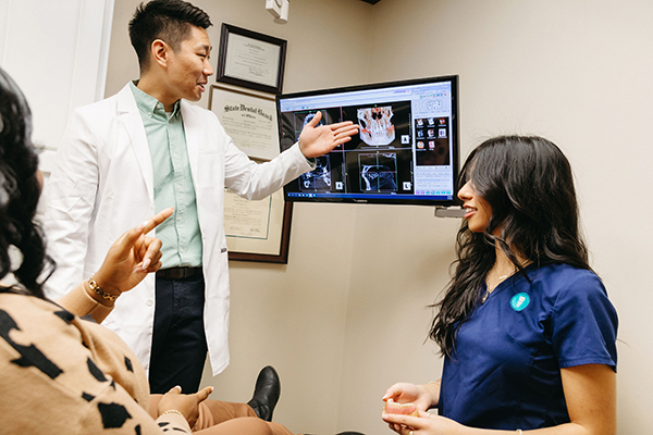 Jacksonville University Implantology resident discussing procedural options with a patient and a female chair-side assistant