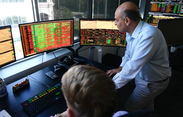 FinTech professor showing data on several computer screens to students