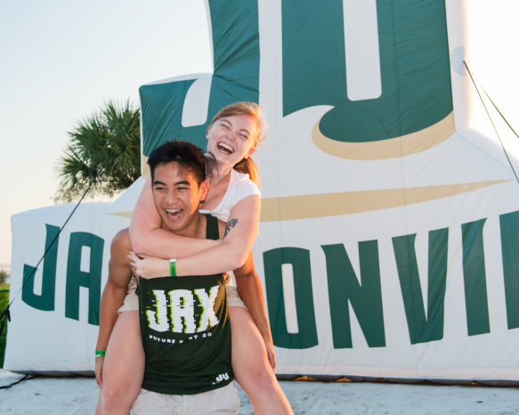 Students posing in front of Jacksonvillle University sign.