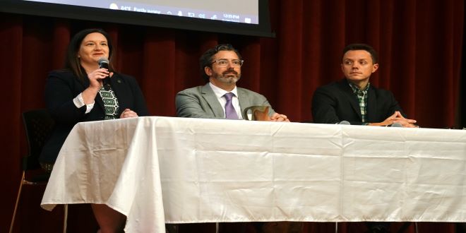 Panel discussion on the right to privacy. Three people at a table in front of a curtain. 