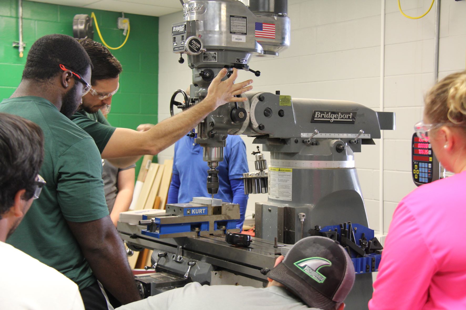 Multiple students working at a machine