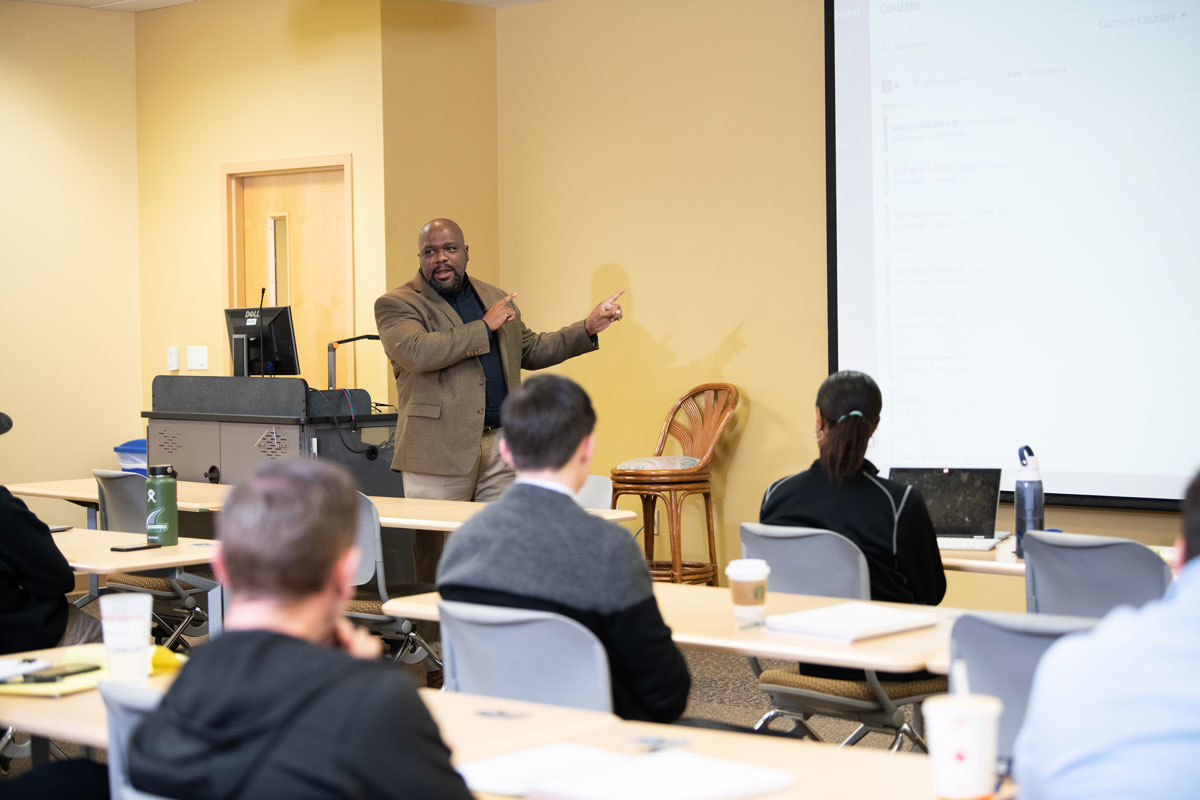 A professor speaking in front of a class.