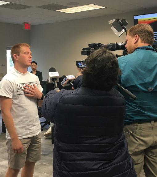 A news crew intervieweing a young student. 