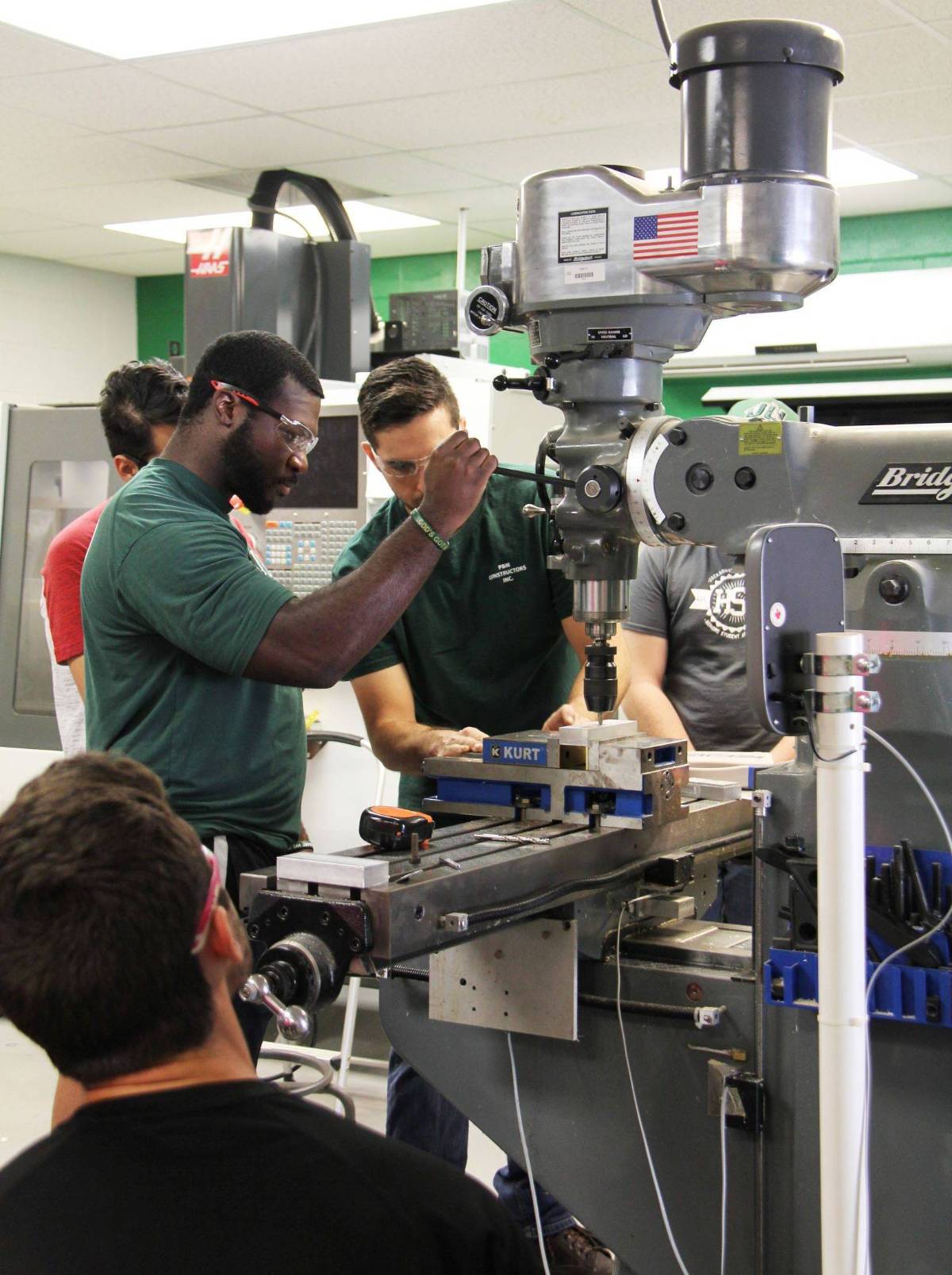 Mechanical engineer students working with engineering machinery.