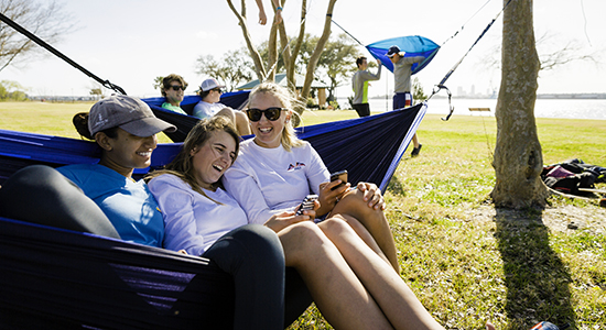 Students in hammocks by the river