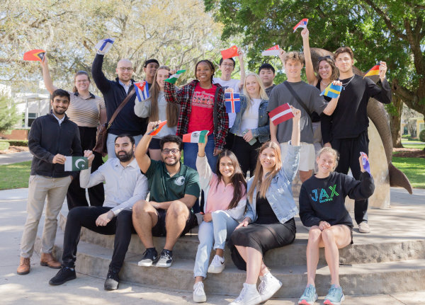 A group of young students signaling the V of victory with their hands