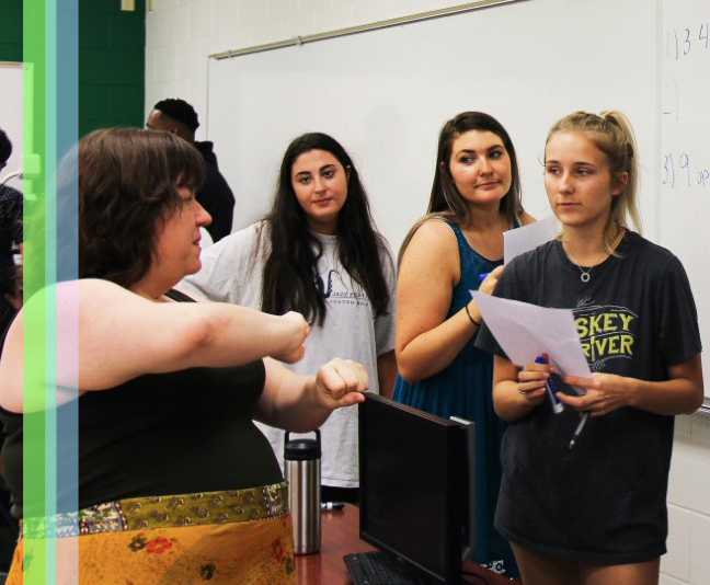 Mathematics professor explaining a math problem to students at the board.