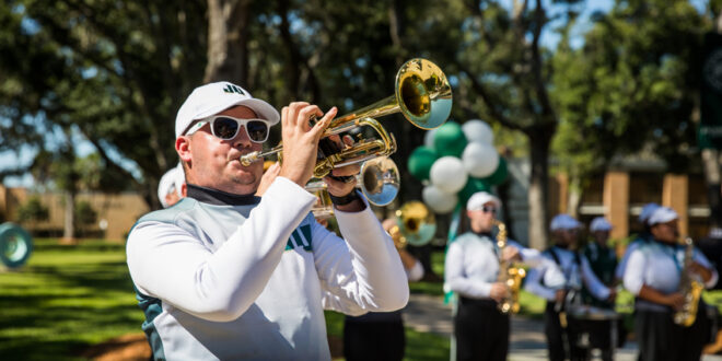 JU pep band player playing the trumpet at Homecoming