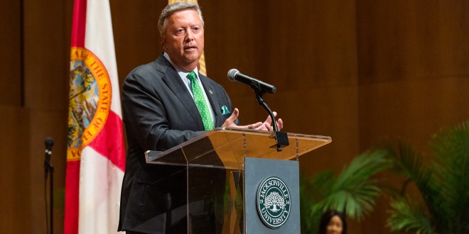 President Tim Cost addressing crowd at a podium.