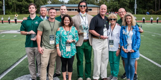 The seven alumni posing with their awards for their service as alumni of distinction.