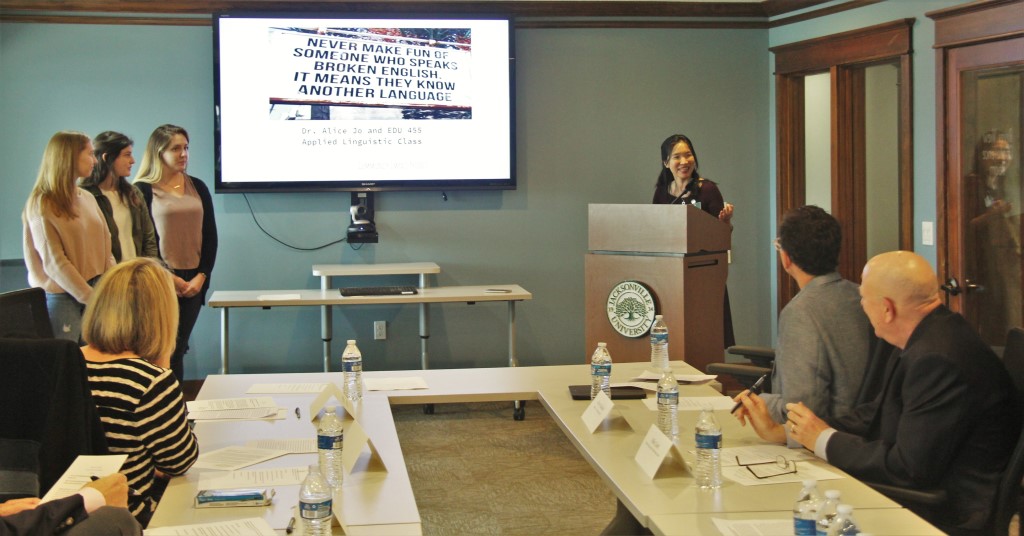 Female speaker stands at podium to address audience