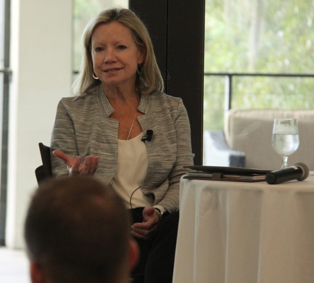 Susan King sits at table and speaks to students