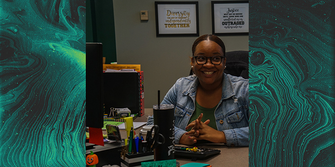 Patrice Abner smiling for a photo while sitting at her desk.