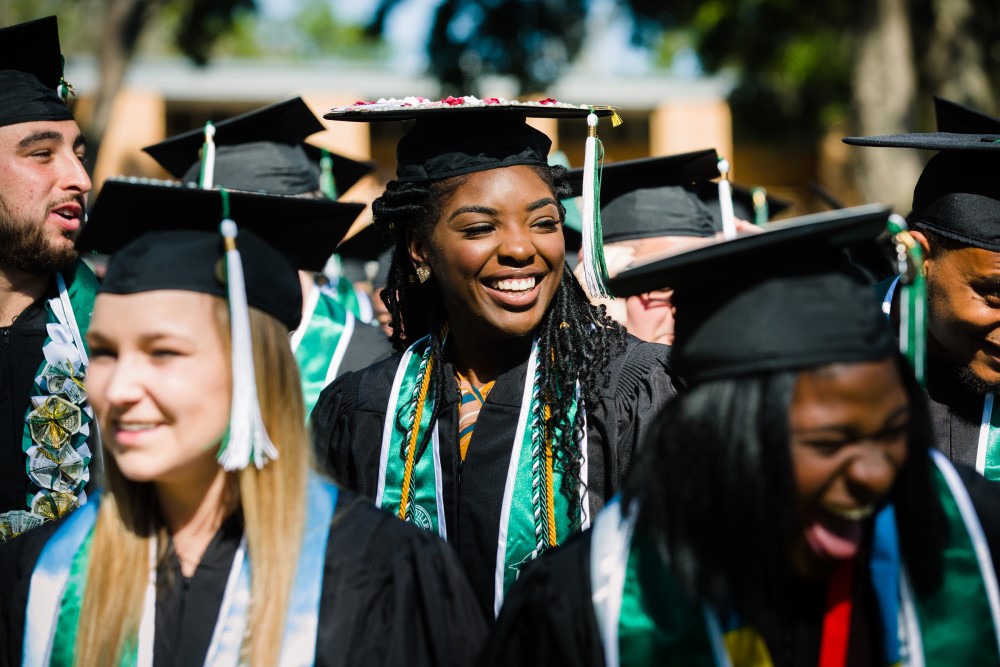 JU students at graduation smiling in the sunshine