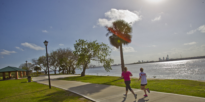 Two runners on JU's Cost Trail by the river.