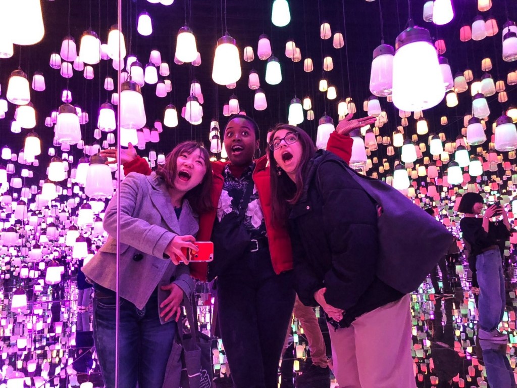 Three female students surrounded by lit lanterns in Tokyo, Japan