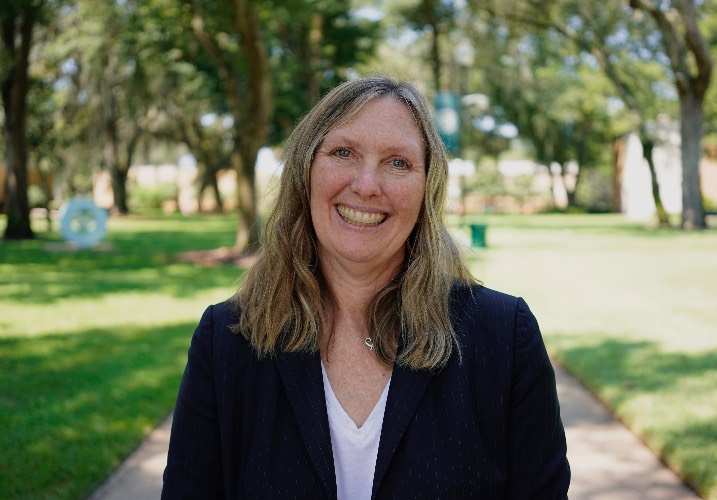 Dr. Sutherland smiles with JU landscape in background