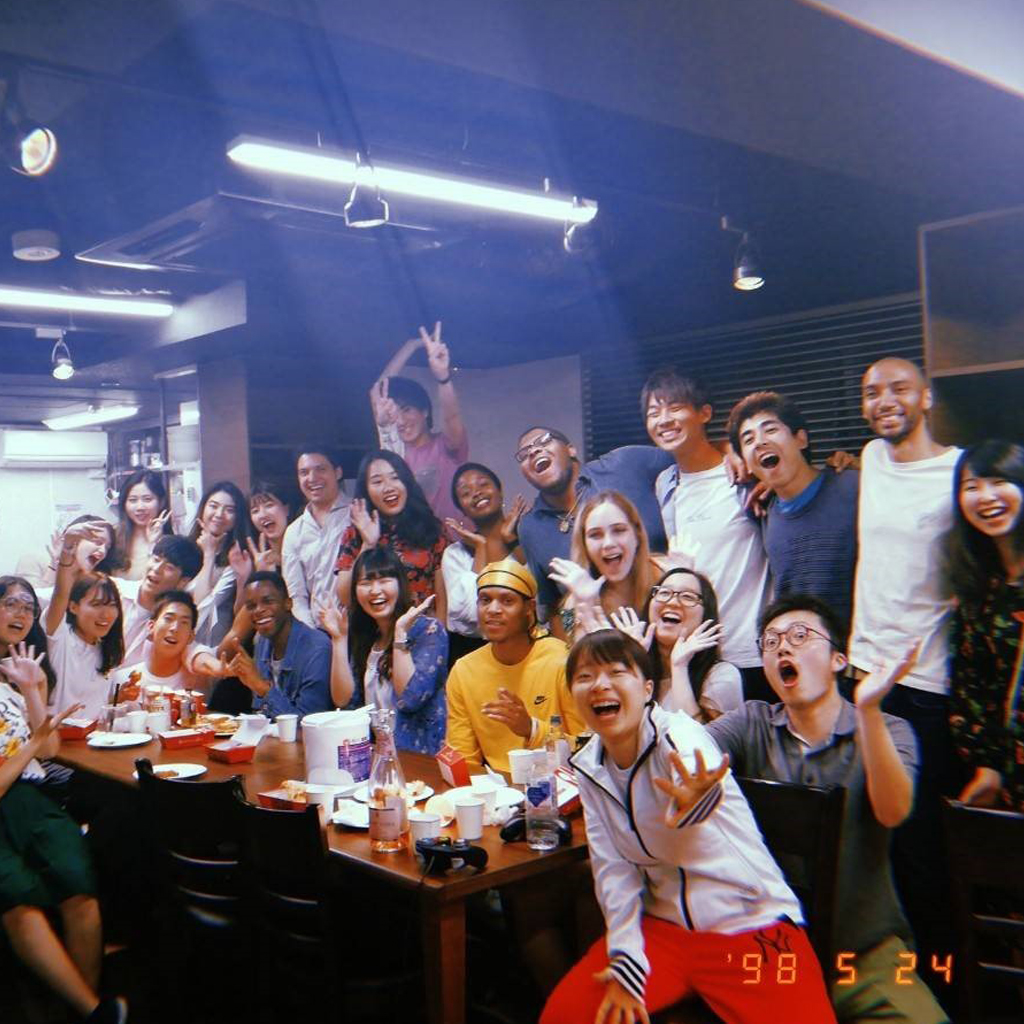 Group of students studying abroad posing for a photo at a local resturant with local patrons