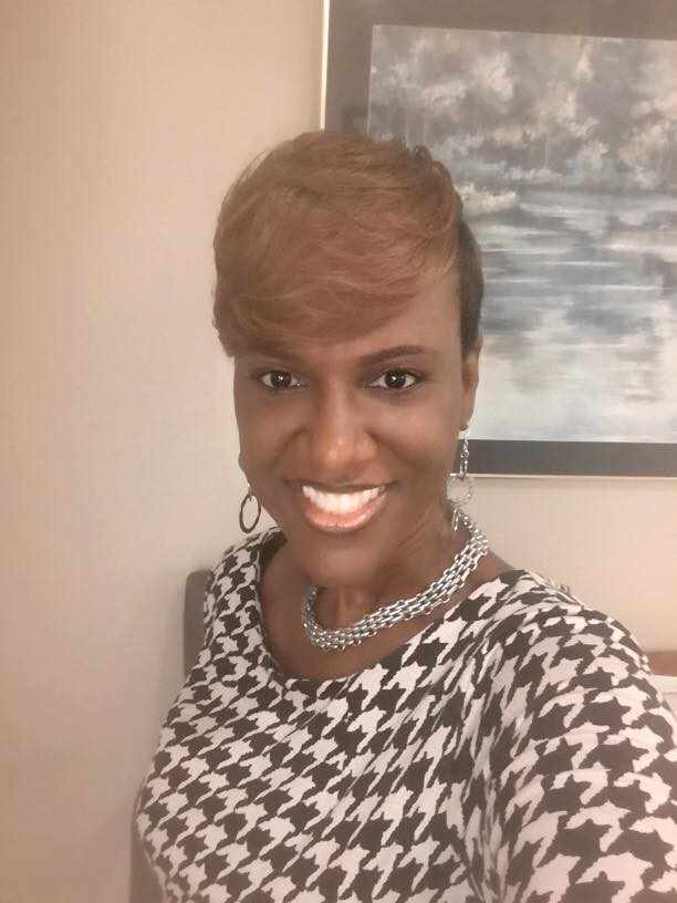 Headshot of an African American woman with shorter hair, blonde, in a professional blouse.