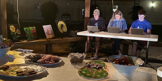 Students working at their computers surrounded with snacks.