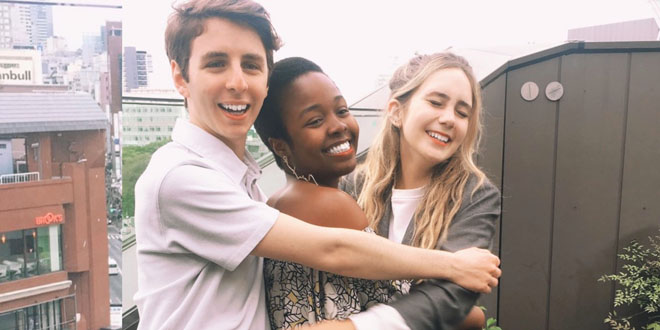 Three JU students in Japan smiling and hugging on a balcony