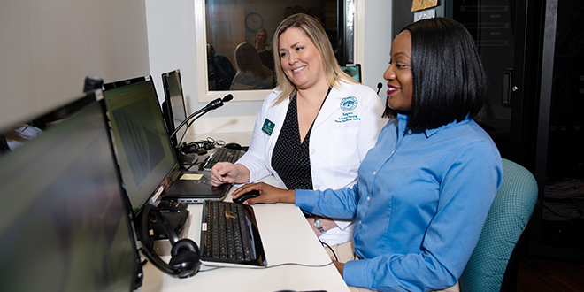 nursing student and professor at computer