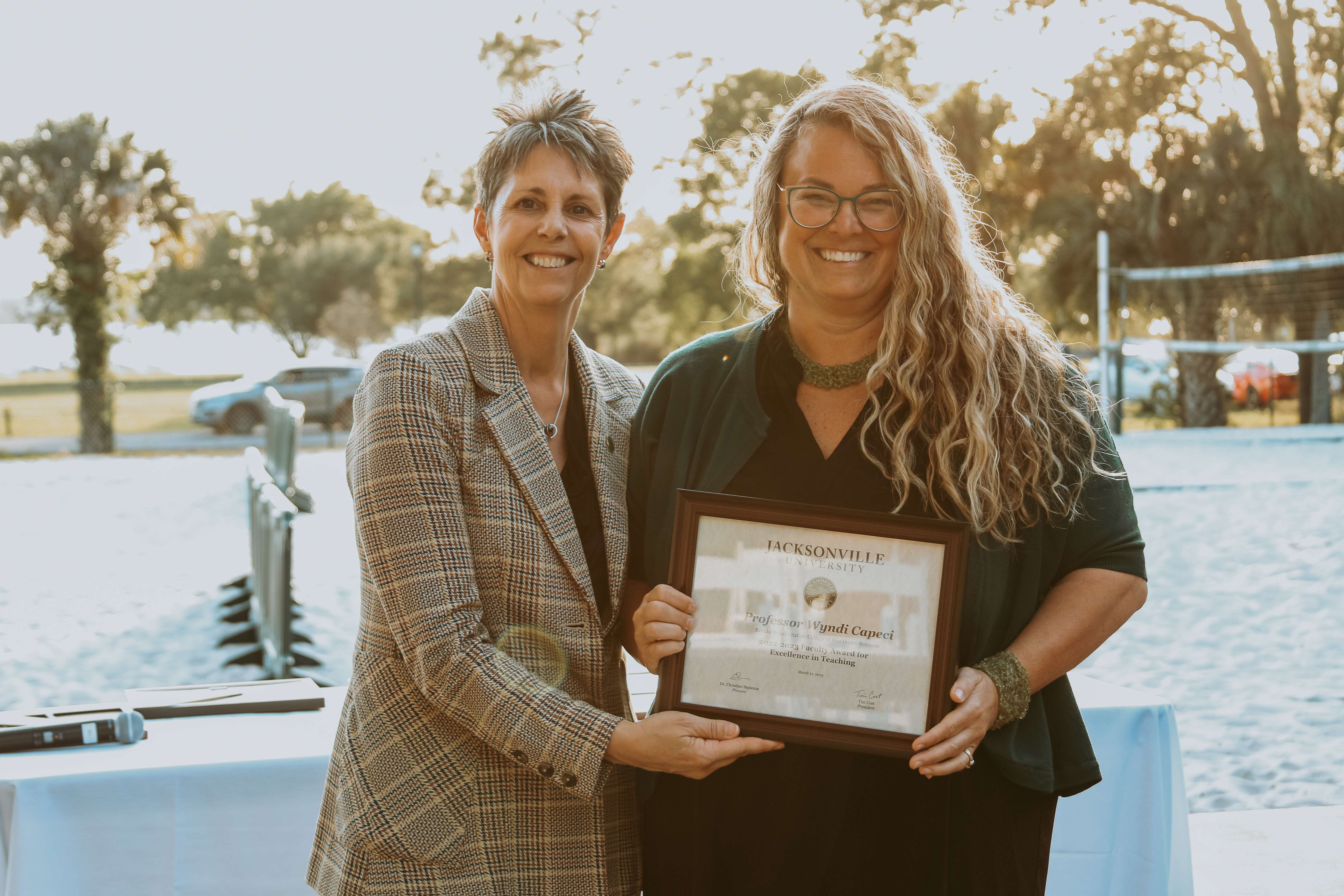 two women holding awards