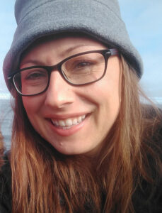 woman with glasses and hat smiling