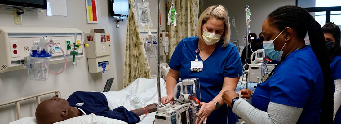 Nursing students practicing in a simulated patient environment.