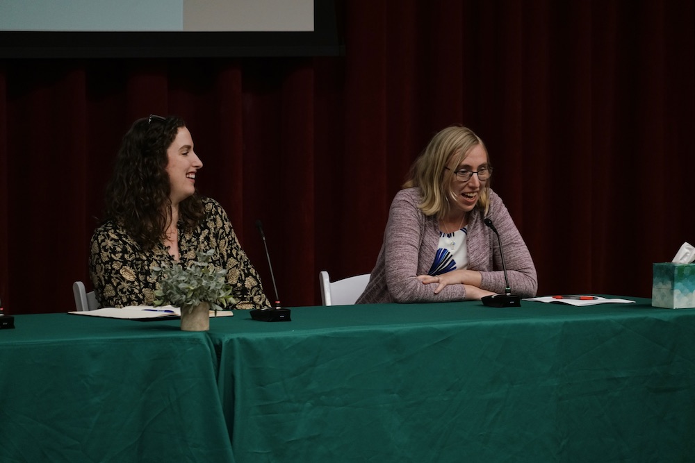 two female experts talking emotively at a panel 