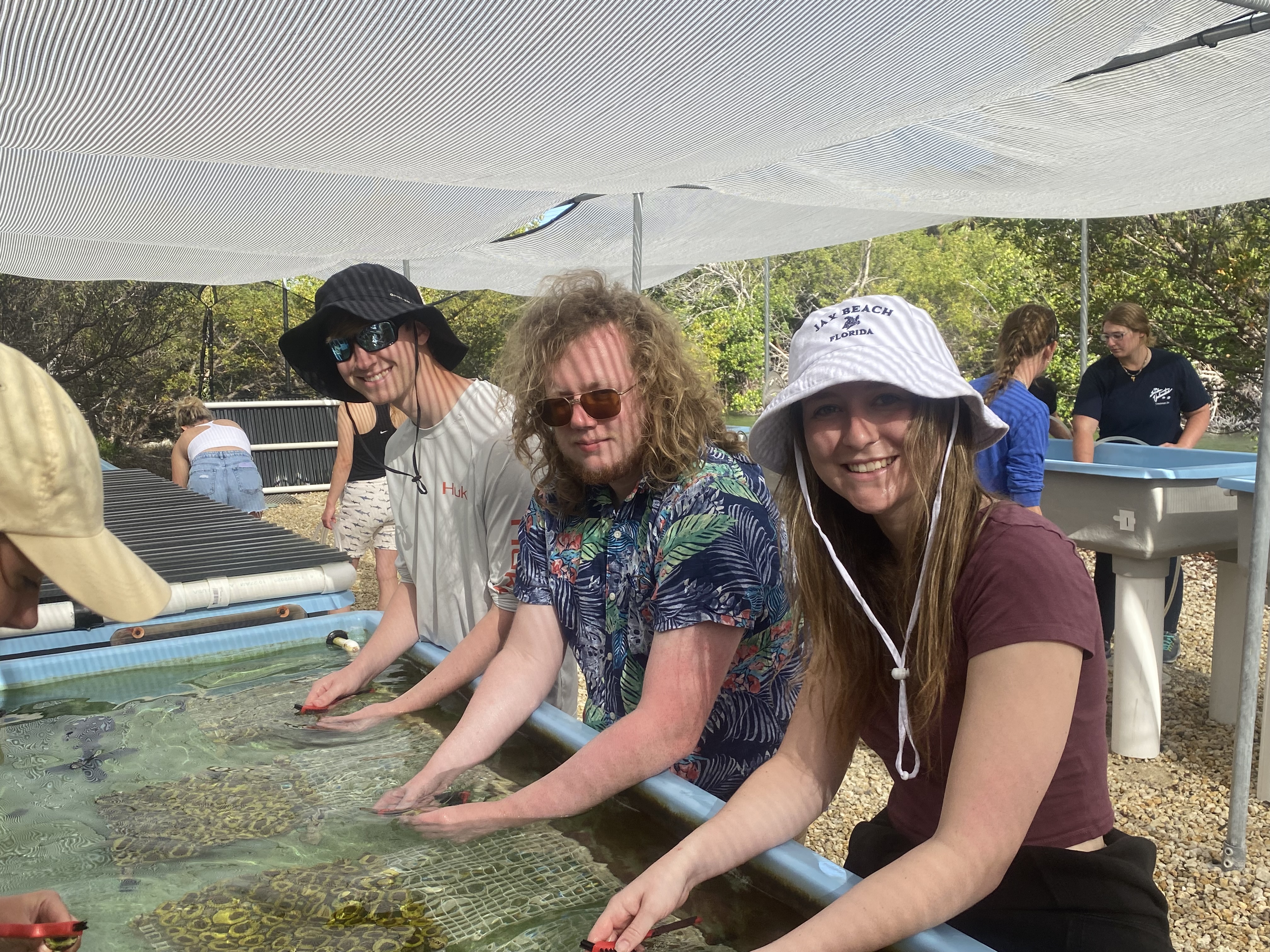 students hold corals in a lab