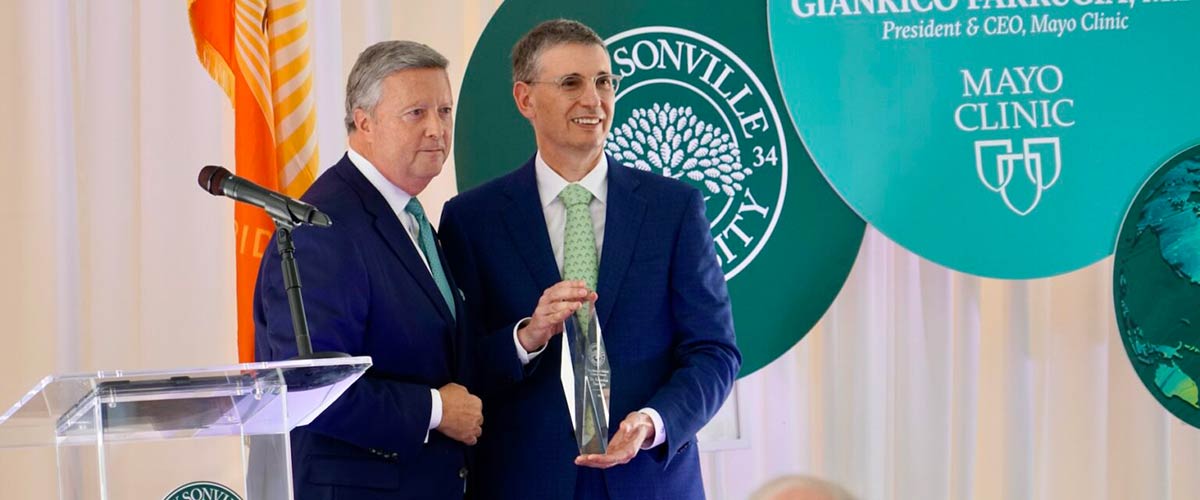 Mayo Clinic President & CEO Gianrico Farrugia, MD, holds the Presidential Global Citizen Award and poses for pictures with President Tim Cost