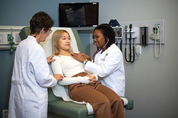 Two nursing students with a patient.