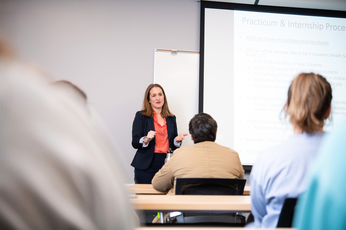 A Psychiatric Mental Health Nursing Educator teaching a room of students.