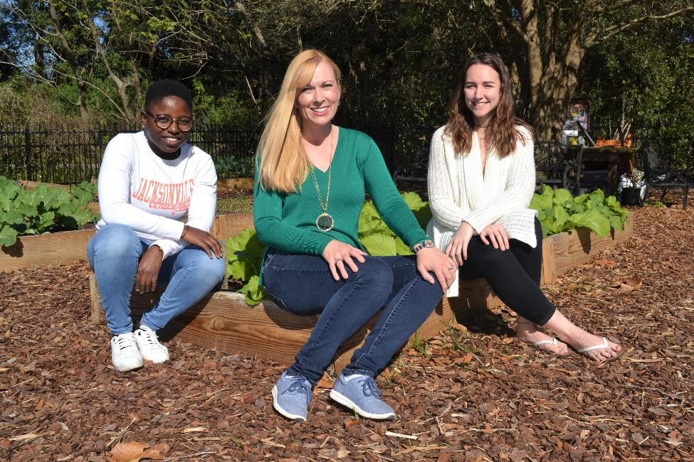 Dr. Atkins in garden with two students