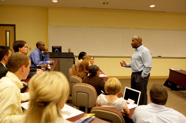 Male professor teaching students in a classroom.