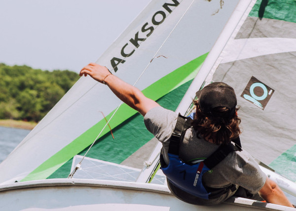 a young person steering a sailing boat