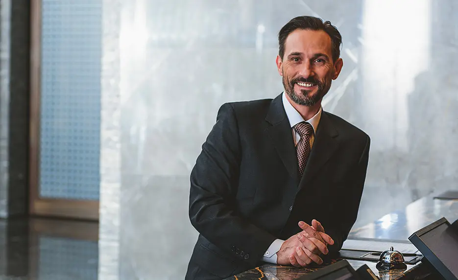 Man in a business suit stops building blocks from falling