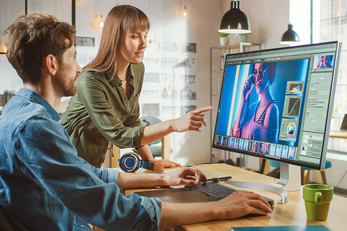 Graphic design student utilizing Adobe graphic design programs on a computer